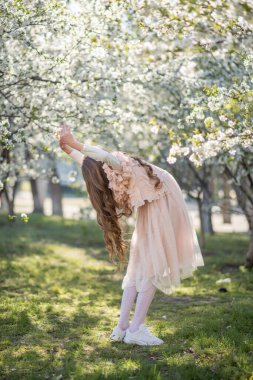 Bahar bahçesinde pembe elbiseli küçük kız