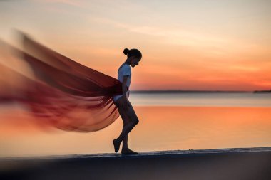 Sahilde yoga yapan bir kadının silüeti. Gün batımında yoga yapan bir kadının silüeti.