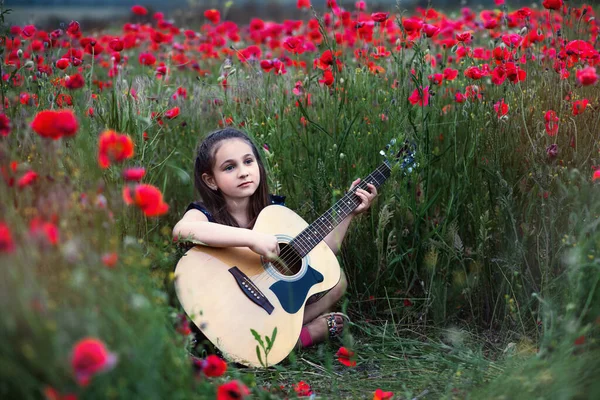 아름다운 아가씨가 양귀비 들판에서 꽃다발 기타를 — 스톡 사진