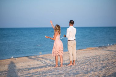 Kumsaldaki genç çift. Sahilde genç bir çiftin silueti.