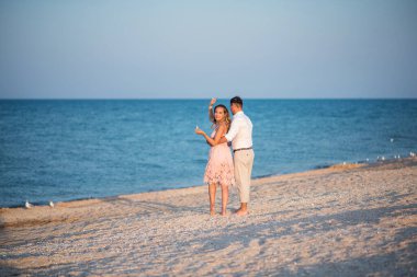 Kumsaldaki genç çift. Sahilde genç bir çiftin silueti.