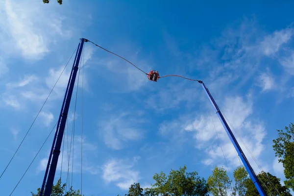 Bir eğlence parkında mavi gökyüzü arka planında yüksek bungee swing