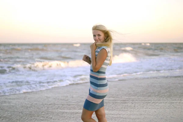 Kumsaldaki genç ve çekici sarışın kadın.