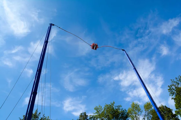 Bir eğlence parkında mavi gökyüzü arka planında yüksek bungee swing