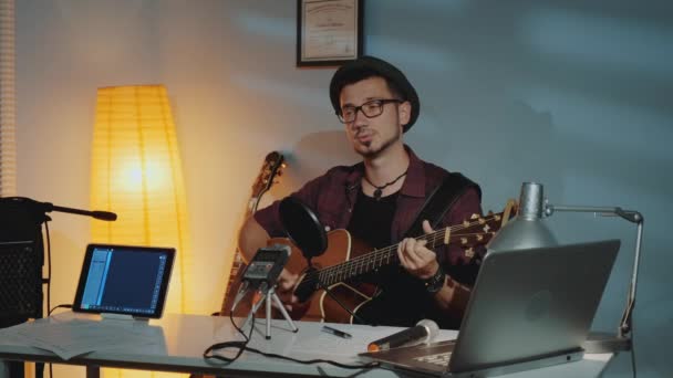Jovem músico bonito gravando sua nova faixa em estúdio em casa — Vídeo de Stock