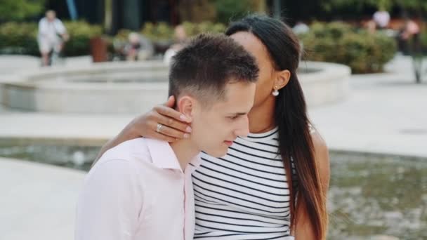Beautiful black woman showing keep silence gesture while whispering something in boyfriends ear — Stock Video