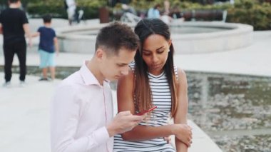 Afrikalı genç bir kadın erkek arkadaşı sürekli akıllı telefondan baktığı için üzgün.