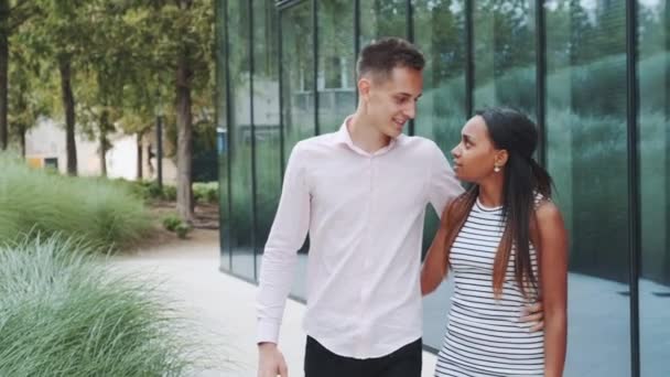 Lång ung man kysser sin afrikanska flickvän när han går nerför gatan — Stockvideo