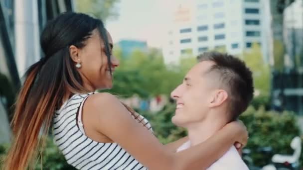 Feliz joven dando vueltas alrededor de su novia de raza mixta en un hermoso lugar al aire libre — Vídeo de stock