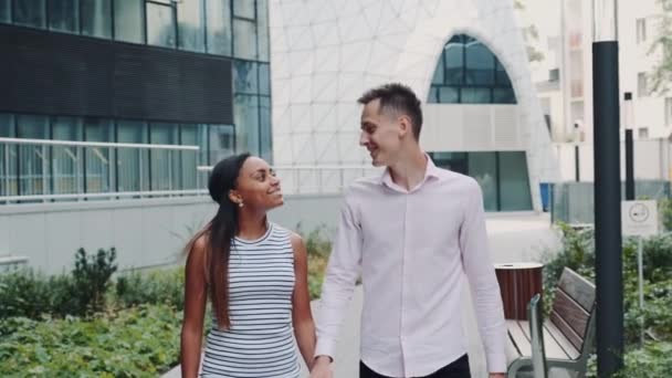 Glückliches multiethnisches Paar, das an einem Sommertag ein Date im modernen Stadtzentrum hat — Stockvideo