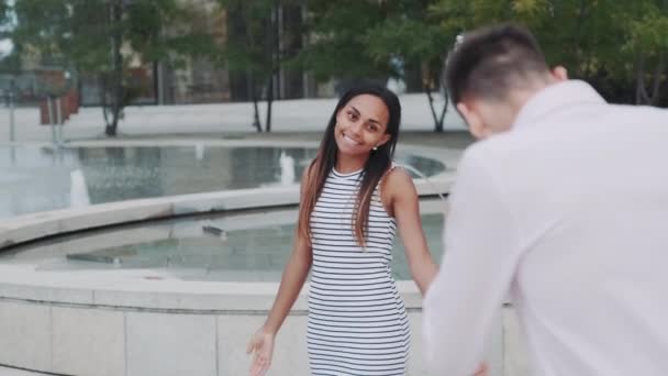 Mladý muž fotografování jeho krásné černošky přítelkyně v centru města — Stock video