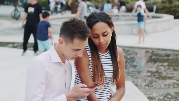 Smíšené-závod dívka žádá svého přítele, aby přestal hledat v smartphonu po celou dobu — Stock video