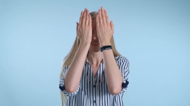 Vacker kvinna täcker sitt ansikte med händer, sedan öppna den och ler — Stockvideo