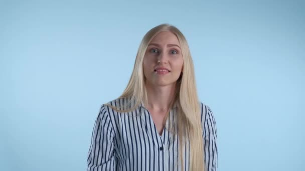 Молодая женщина показывает жесты "уйти" на синем фоне — стоковое видео