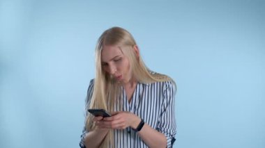 Çekici genç bayan akıllı telefondan bir şeye bakmaktan çok memnun.
