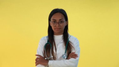 Sarı arka planda el sallayan melez kadın doktorların yakın çekimi..