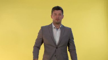 Takım elbiseli zarif bir adam ellerini yana açıyor ve diyor ki: