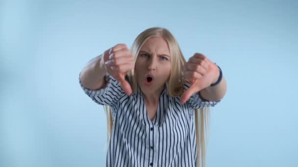 Nyugtalan fiatal nő negatív érzelmeket mutat és hüvelykujját lefelé nyújtja — Stock videók