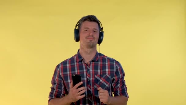 Красивый мужчина в наушниках наслаждается музыкой — стоковое видео