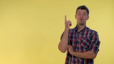 Neşeli genç bir adam birinden bahşiş alıyor ve işaret parmağını yan tarafa gösteriyor..