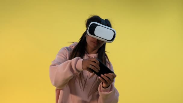 Chica multiracial en gafas de realidad virtual jugando juegos en línea en el teléfono inteligente — Vídeo de stock