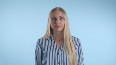 Sarışın genç kadın mavi arka planda bir şeyleri yanlış anlamış..
