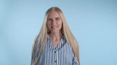 Dudaklarını ısıran ve gülümseyen çekici genç bayan.