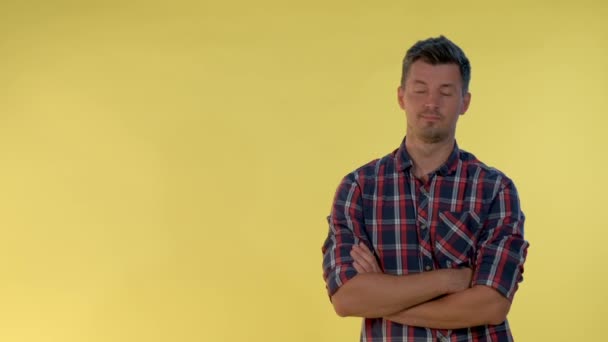 On yellow background cheerful tall boy making a hush gesture. — Stock Video