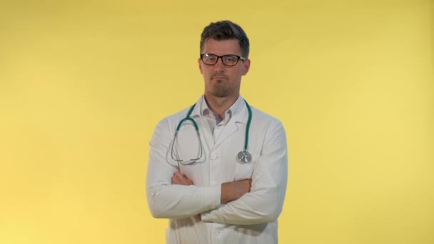 Good-looking young doctor in lab coat showing that he cant help in this situation and spreading hands to the sides. — Stock Video