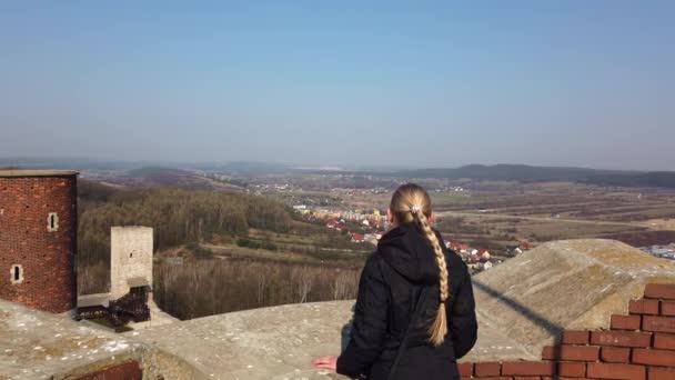 Attraktive Reiseleiterin schaut sich im Tal nahe der alten Burg um — Stockvideo