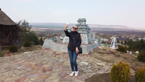 Kadın, minyatür bir Çin pagodasının yanında selfie çekiyor. Minyatürler Parkı. — Stok video