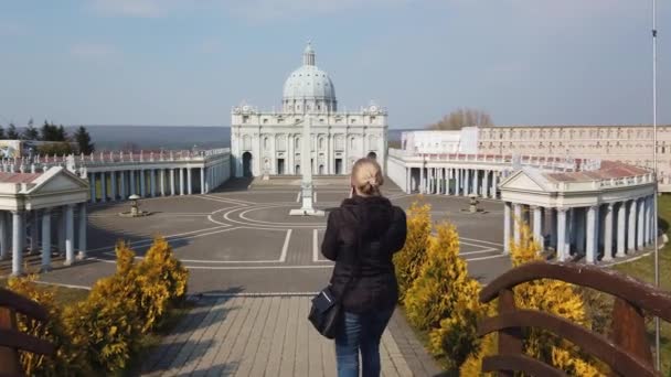 Femmina fa foto camminando a piedi vicino a un modello in miniatura della Basilica di San Pietro, Vaticano. Parco delle Miniature. — Video Stock