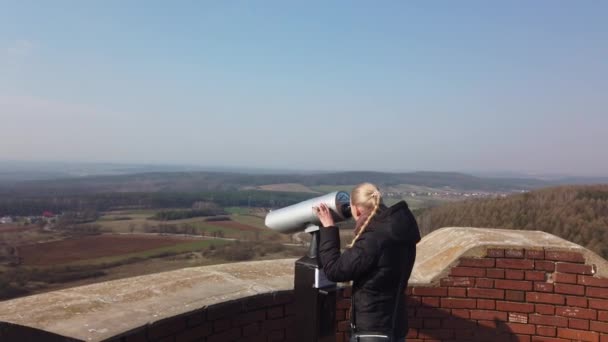 Atractivo viajero femenino usando binocular para mirar alrededor del valle cerca del antiguo castillo — Vídeos de Stock