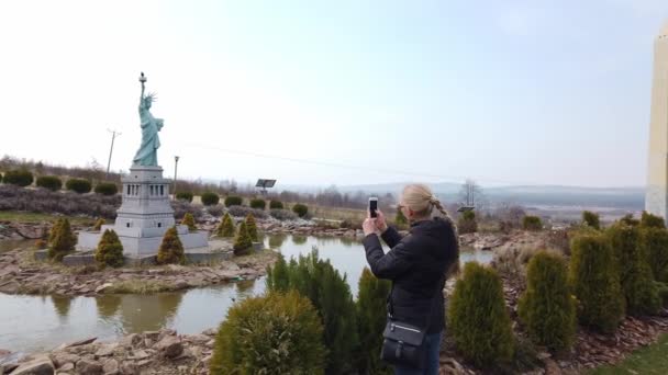 Hembra hace foto caminando a pie cerca de un modelo en miniatura de la Estatua de la Libertad, Nueva York. Parque de Miniaturas . — Vídeos de Stock