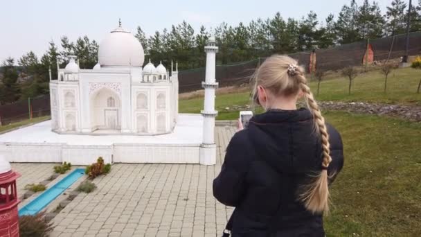 Kvinna gör foto promenader till fots nära en miniatyr modell av Taj Mahal byggnaden. Miniatyrpark. — Stockvideo