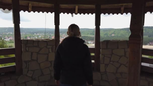 Приваблива жінка мандрівник використовує бінокль для пошуку навколо долини біля старого замку — стокове відео