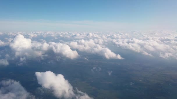 Bela vista aérea em terra e nuvens brancas fofas através da janela do avião voador . — Vídeo de Stock