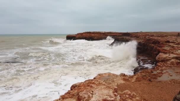 Błyszczące fale oceaniczne ze skałą, fale rozpryskujące się o przybrzeżną skałę, fale rozbijające pianę skalistą — Wideo stockowe