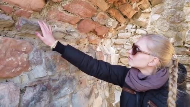 Touriste regarde un mur de pierre dans l'ancien château. — Video