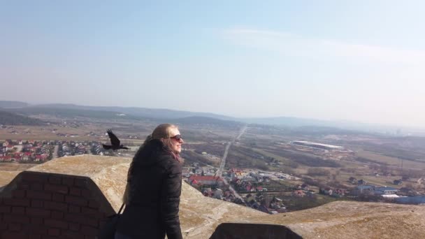 Attractive female traveller looking around valley near the old castle — Stock Video