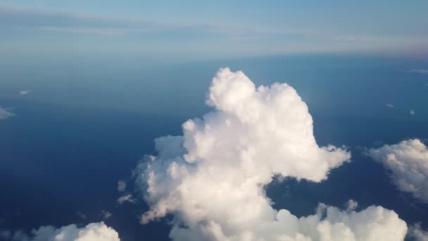 Krásný letecký pohled na zemi a bílé nadýchané mraky oknem na létající letadlo. — Stock video