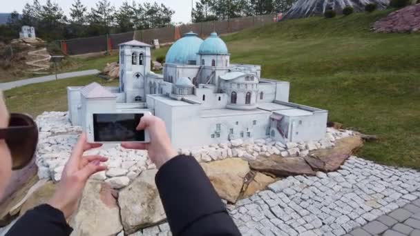 Mujer toma una foto cerca de un edificio en miniatura en el estilo árabe oriental. Parque de Miniaturas . — Vídeos de Stock