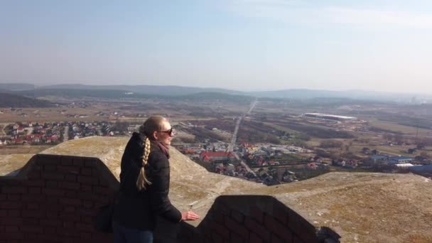 Vonzó női utazó néz körül völgyben, közel a régi vár — Stock videók