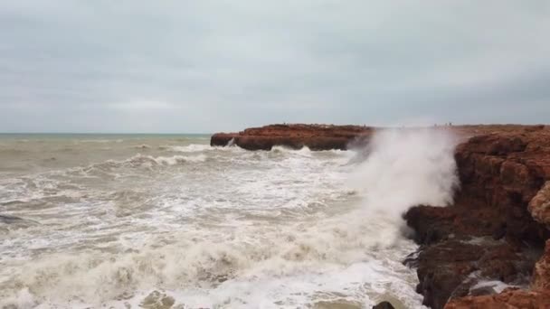 Kara kayanın üzerinde dalgalar kırılıyor. — Stok video