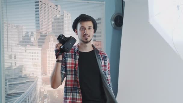 Jovem fotógrafo sorrindo posando com sua câmera profissional — Vídeo de Stock