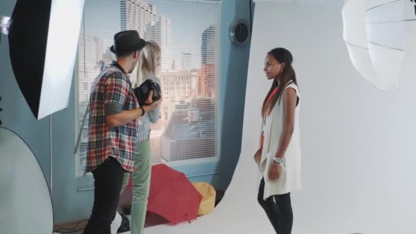 Joven modelo africano posando en una silla alta de bar durante la sesión de fotos — Vídeo de stock