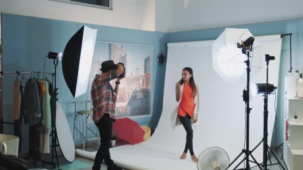 Foto tiro nos bastidores: atraente modelo africano posando em estúdio com equipamento de fotografia moderna — Vídeo de Stock