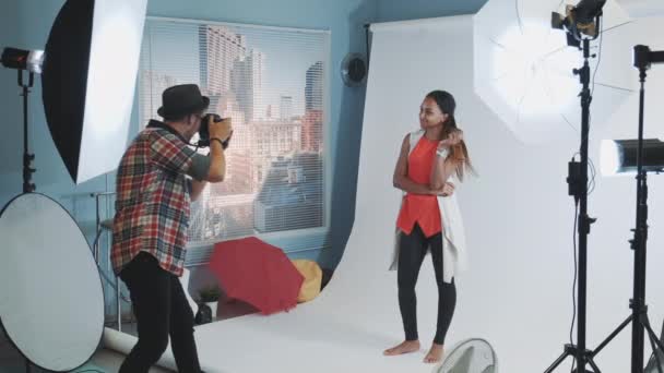 professioneller Fotograf bittet Model, Posen zu ändern, während sie ein Fotoshooting im Studio machen