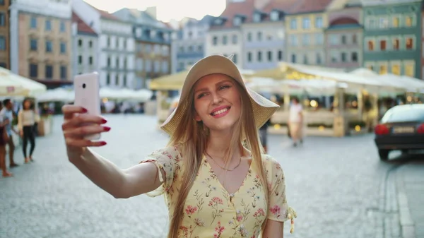 Femme prenant selfie sur carré. Fille attrayante posant pour selfie et debout sur la place de la ville . — Photo