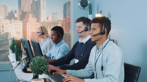 Diverse team of call center customers looking to the camera and smiling — Stockvideo